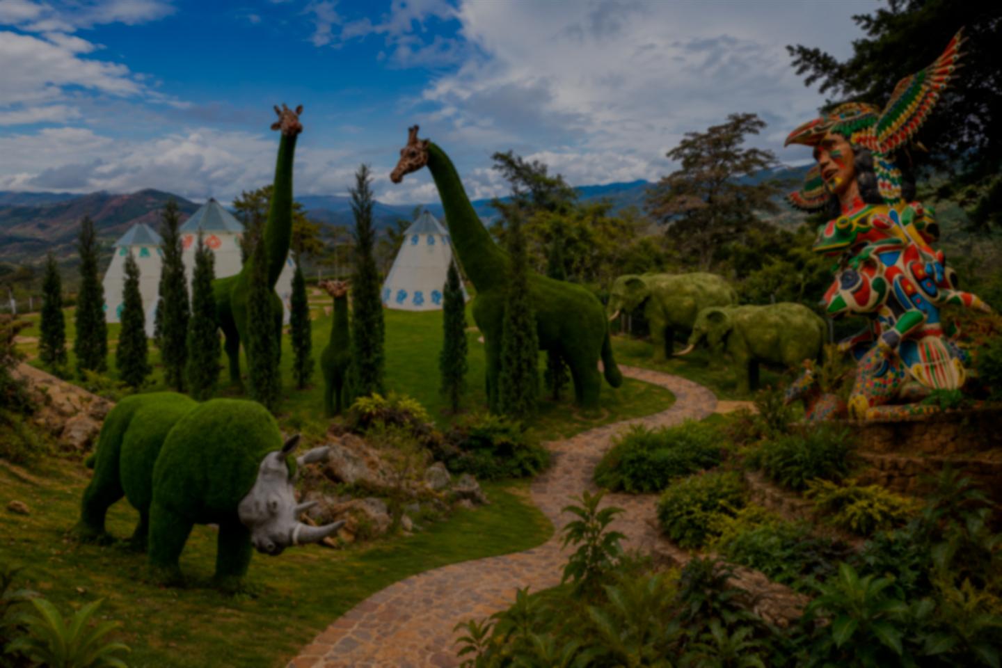 Vista panorámica del jardín topiario de Hotel Pauché, con jirafas, elefantes, rinoceronte y tótem